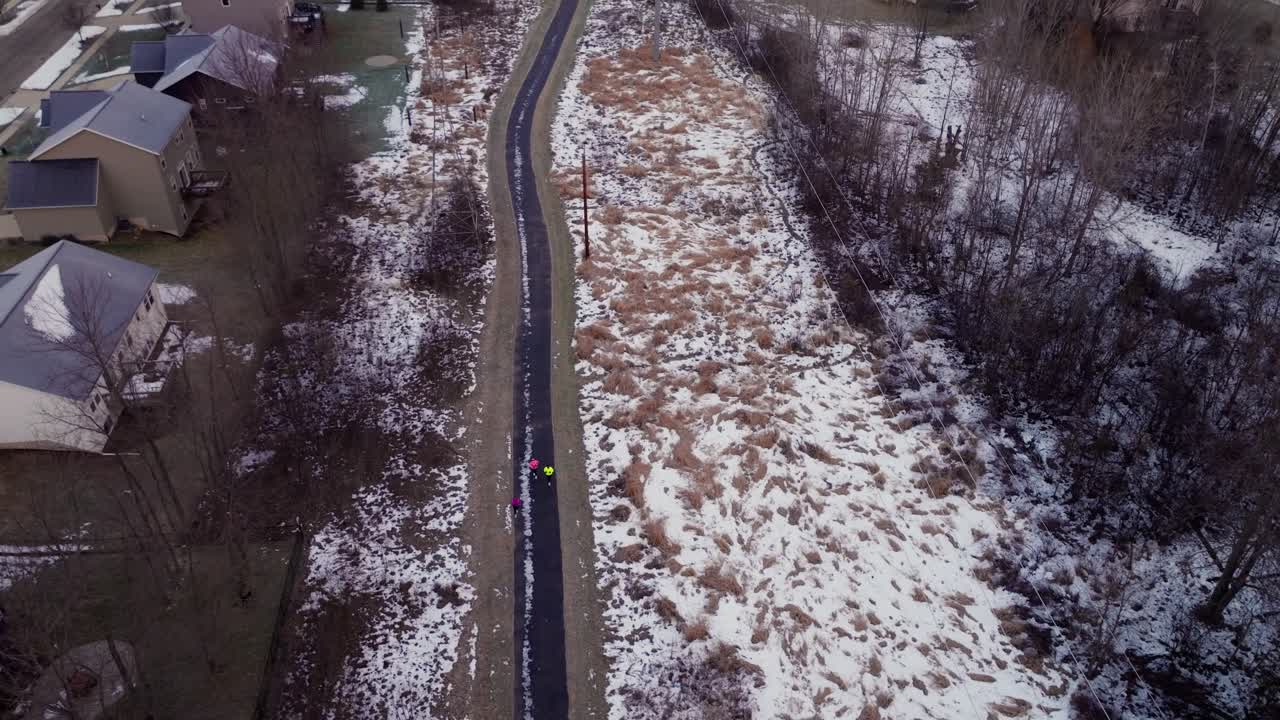 4K drone-luftoptagelser af en livlig vintersolopgang over forstadskvarterer i Grand Rapids, Michigan, med sneklædte hustage, farverig himmel og rolig morgenstemning