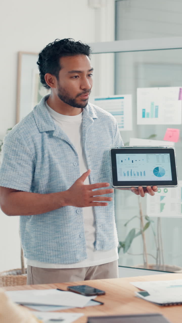 Man Presenting Business Data on Tablet in Modern Office