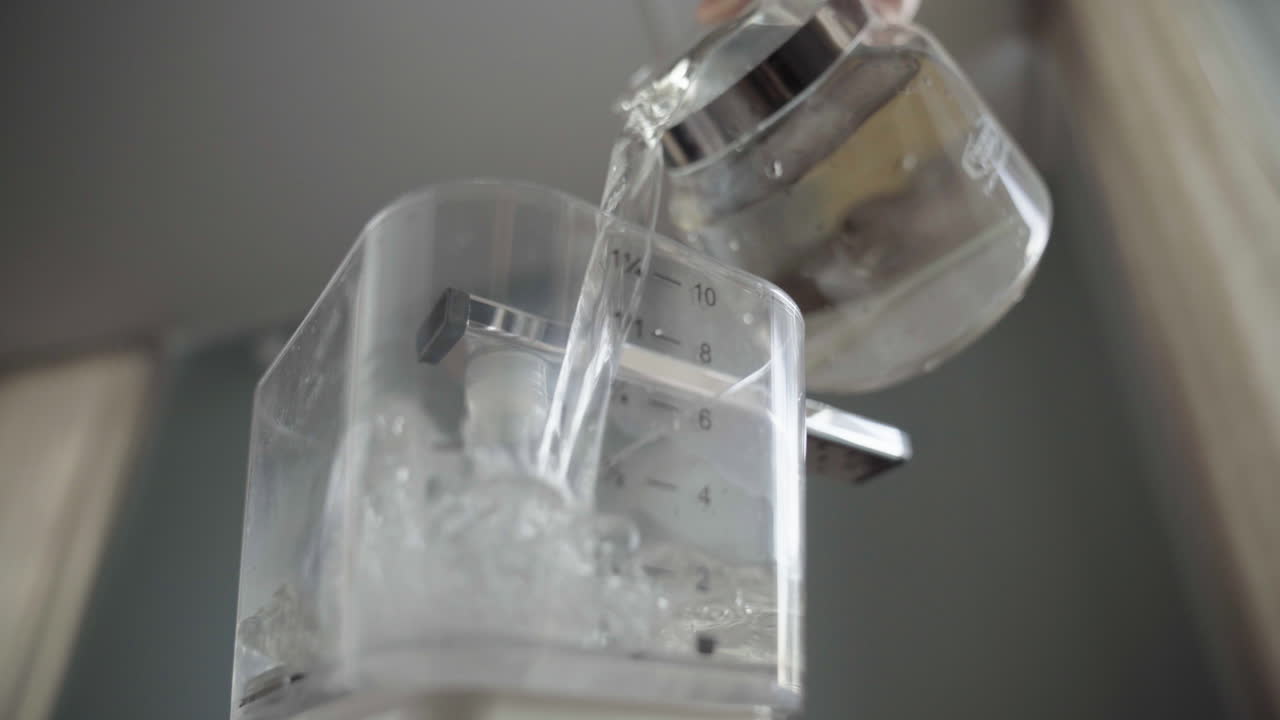 커피메이커에 물 붓기. 낮고 넓은 각도