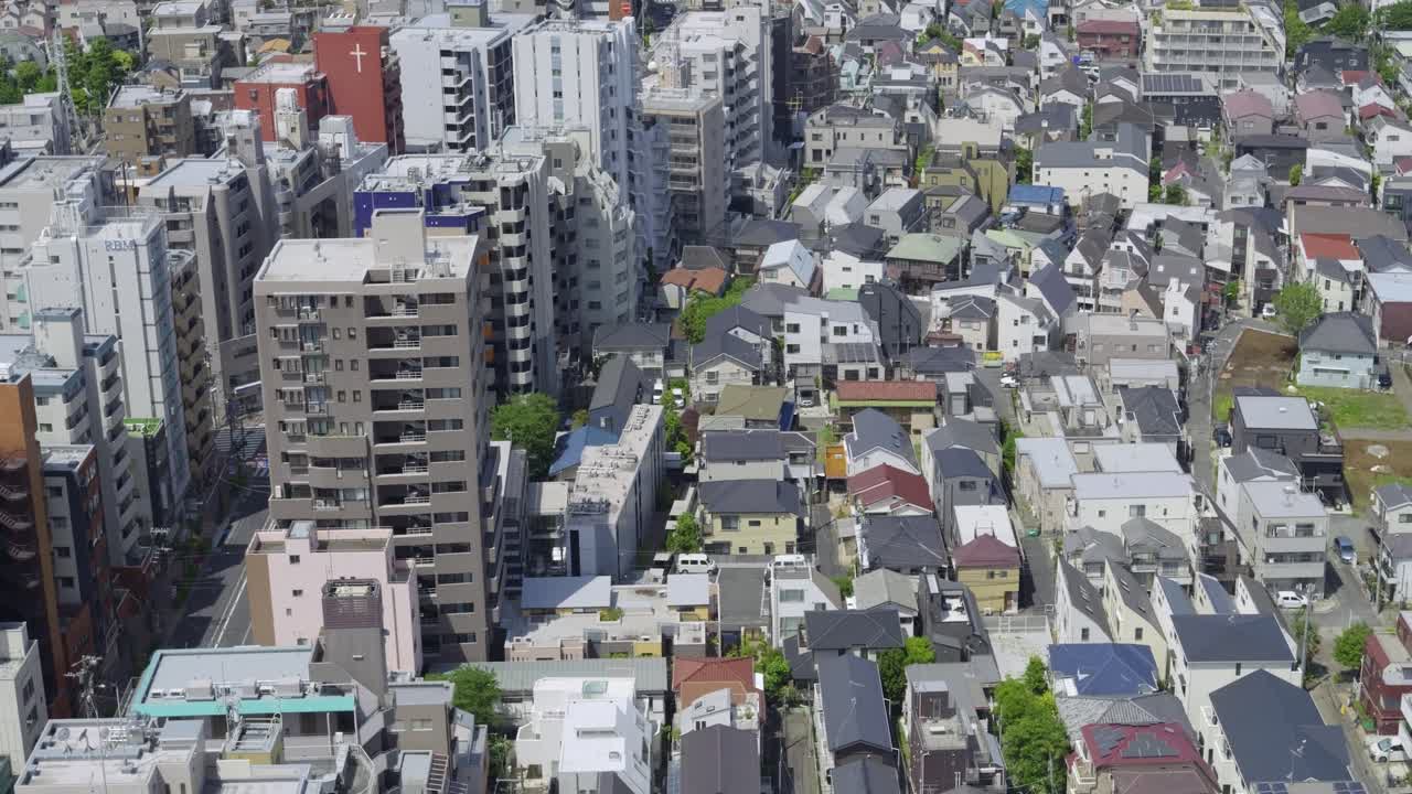 Slow motion tilt up over Tokyo cityscape on sunny day
