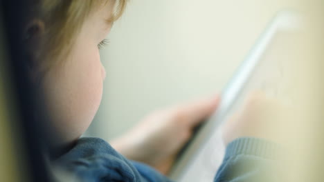 Close-up-shot-of-boy-playing-with-pad-in-the-train