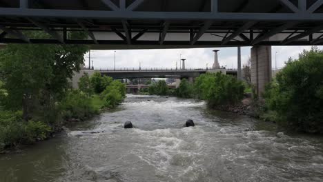 Drone-fly-under-the-bridge-above-South-Platte-River-in-Denver-city,-Colorado,-United-States