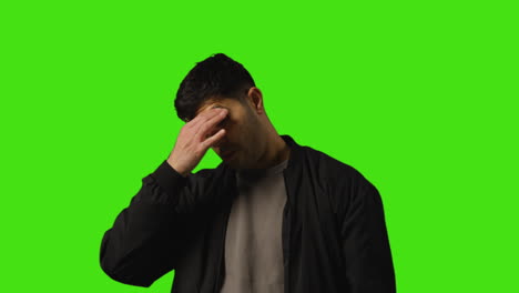 Portrait-Shot-Of-Worried-Or-Stressed-Looking-Man-Standing-Against-Studio-Green-Screen-Background