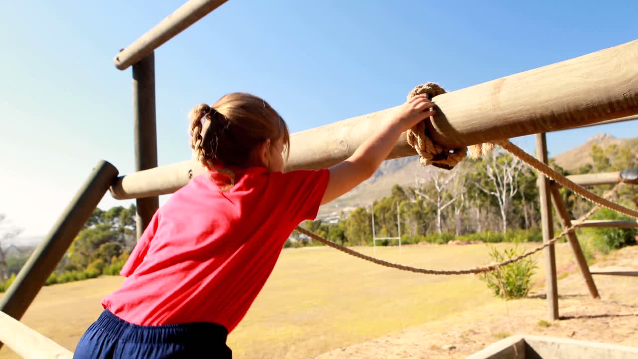 niña haciendo ejercicio en equipos al aire libre durante una carrera de obstáculos