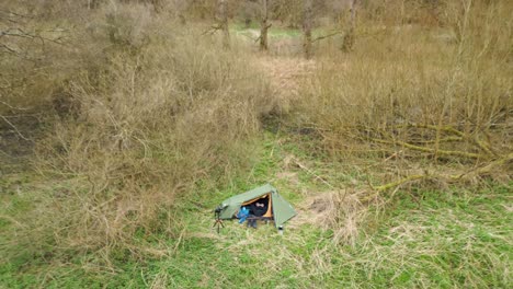 Mann-Sitzt-Im-Campingzelt-Und-Fliegt-Mit-Einer-Drohne-Im-Thetford-Forest-In-Norfolk,-Großbritannien