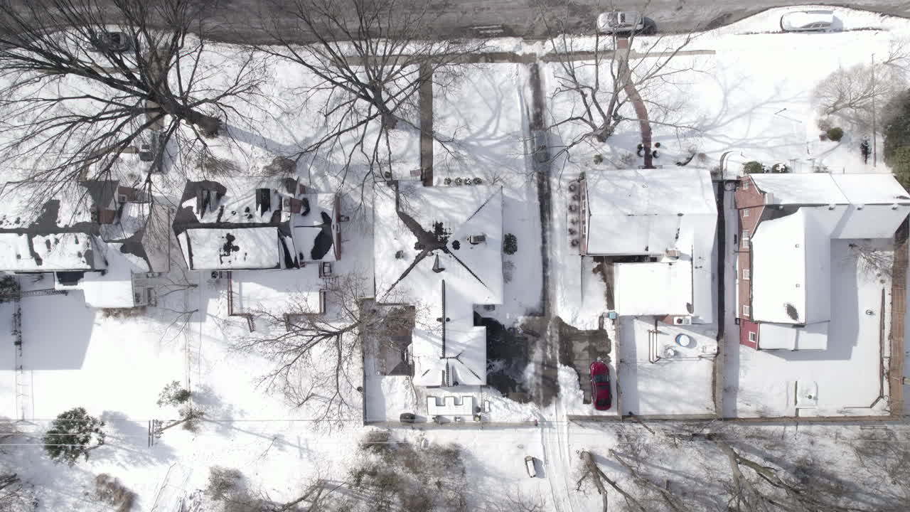 눈 내리는 겨울날 교외의 진입로로 진입하는 자동차의 하향식 조감도