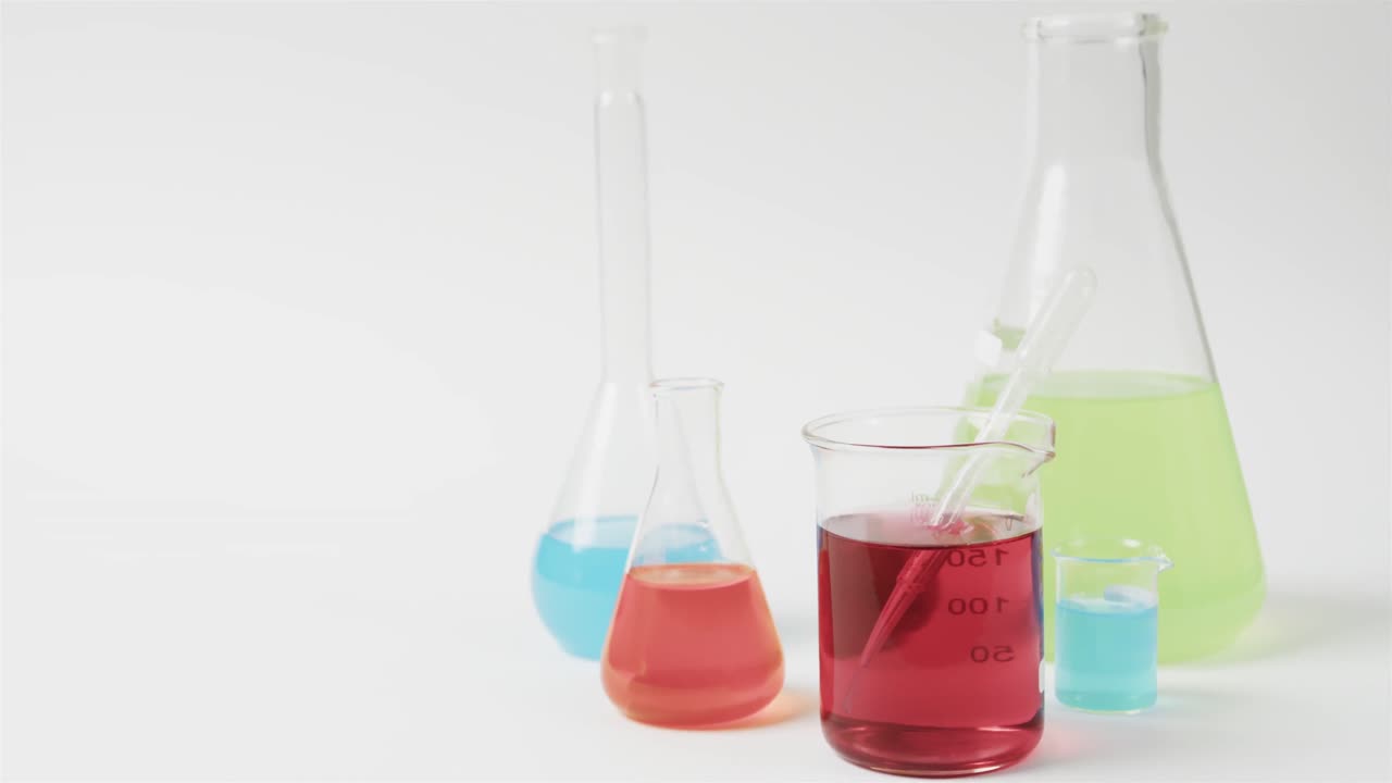 líquidos de color en frascos sobre fondo blanco con espacio para copiar, cámara lenta