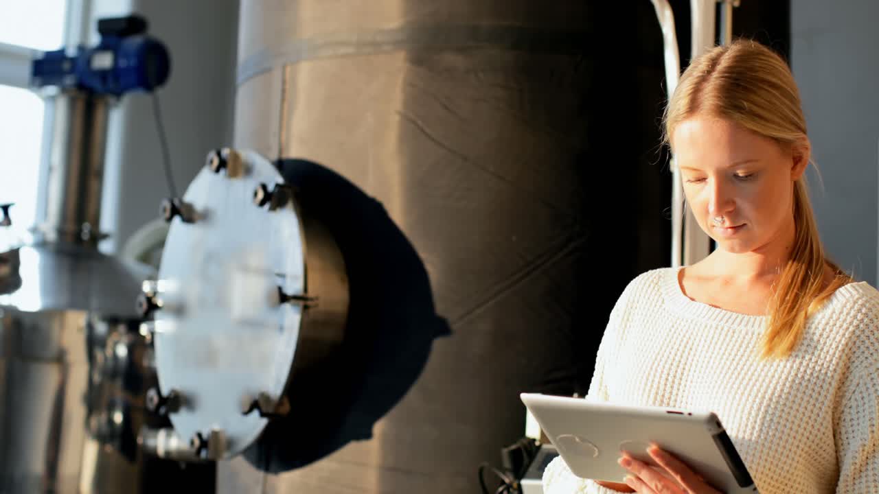 trabajadora que usa una tableta digital en una fábrica de destilería 4k