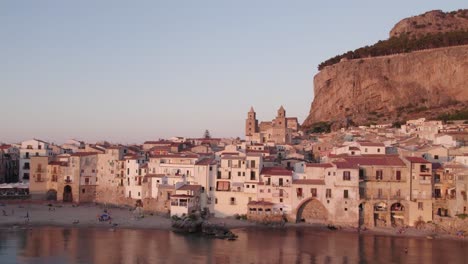 Aerial-view-of-Cefalu-medieval-city-during-summer-at-sunset,-Sicily,-Italy