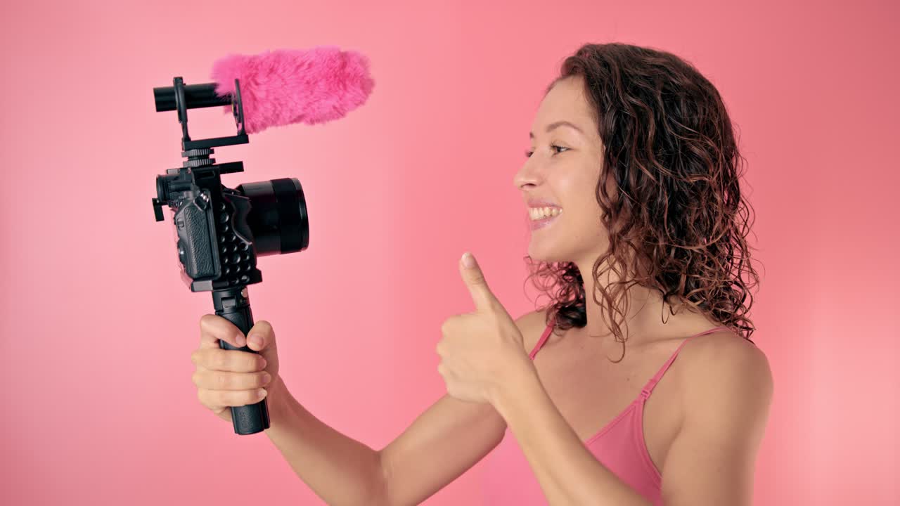 Woman vlogger with pink microphone and camera