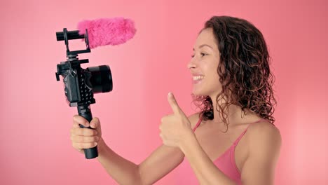 woman vlogger with pink microphone and camera