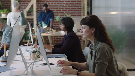 young caucasian business woman using computer in diverse modern office workspace colleagues working on corporate project creative multi ethnic team