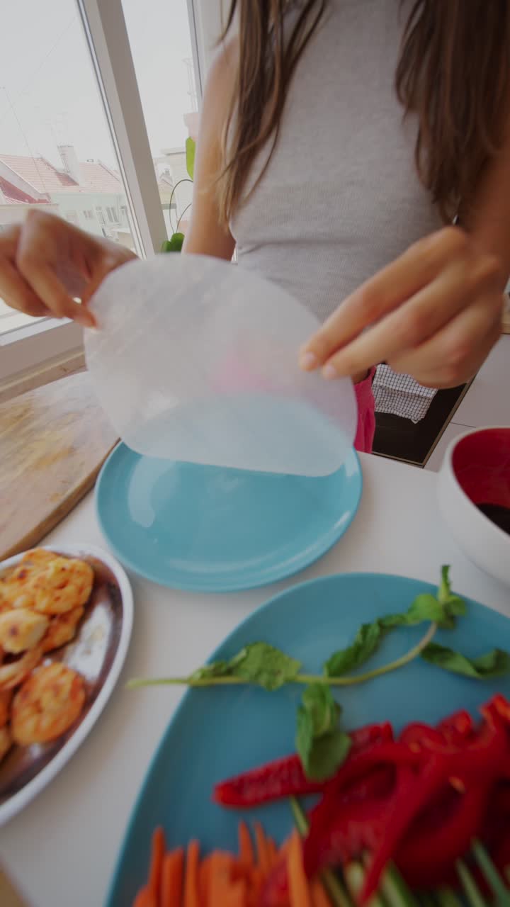 Woman Preparing Spring Rolls with Shrimp in a Kitchen