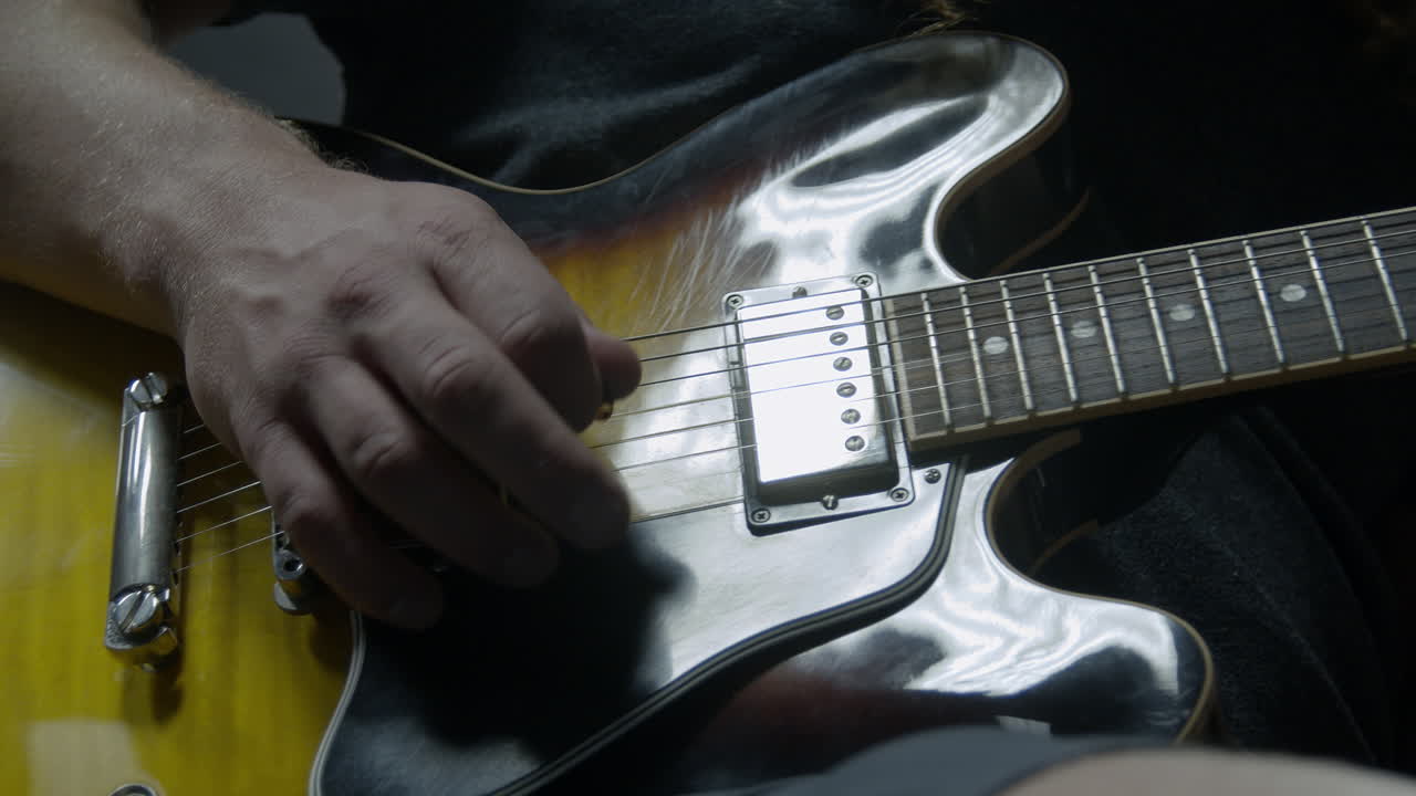 Primo piano di una chitarra suonata da un chitarrista professionista.
