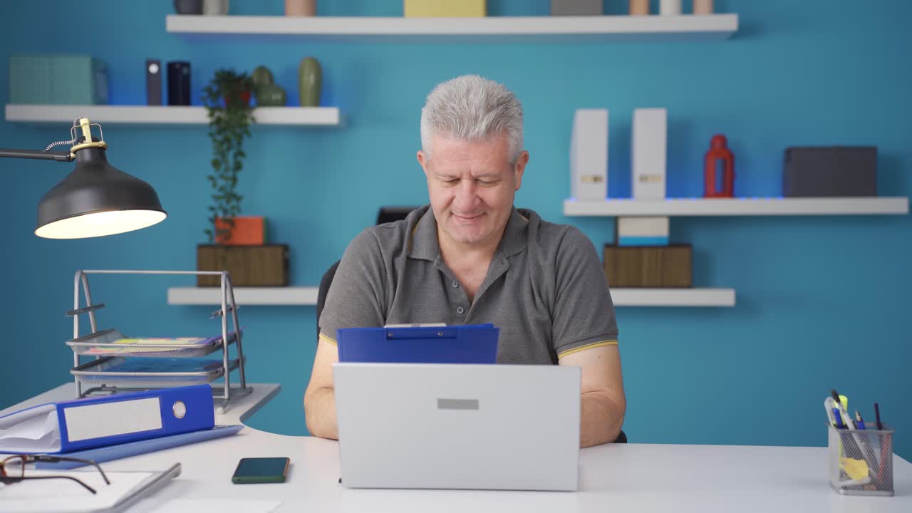 Home office worker man looking at paperwork files.