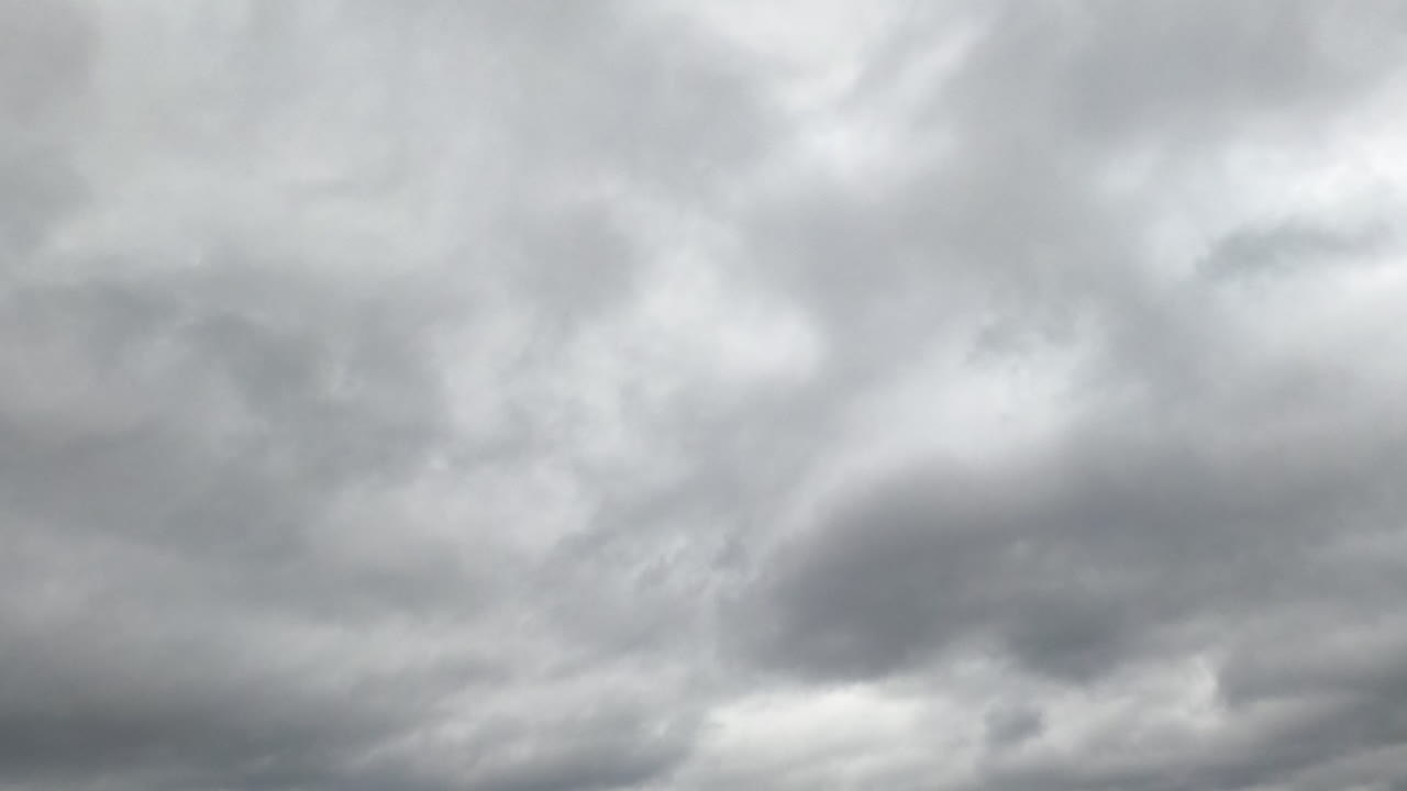 Rainy cloudscape formation in the sky at daytime. Gloomy weather horizon covered with clouds. Low angle view. Timelapse.