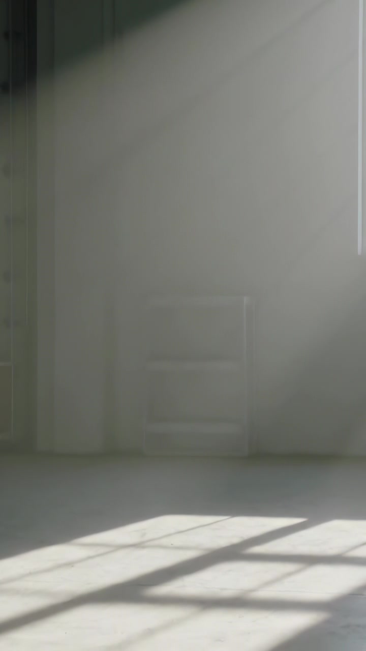 Video verticale: Telecamera in panoramica che rivela un raggio di sole dalla finestra di destra che proietta un'ombra a griglia sul pavimento.