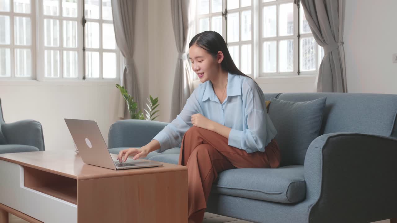 Woman Sitting Sofa And Use Laptop Computer In Home Living Room, Video In 4K