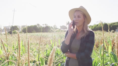 Video-Einer-Glücklichen-Kaukasischen-Frau,-Die-An-Einem-Sonnigen-Tag-Tablet-Und-Smartphone-Im-Feld-Benutzt