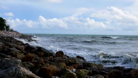 sea waves water on rocky beach at summer day. close up water waves splashing on ocean beach