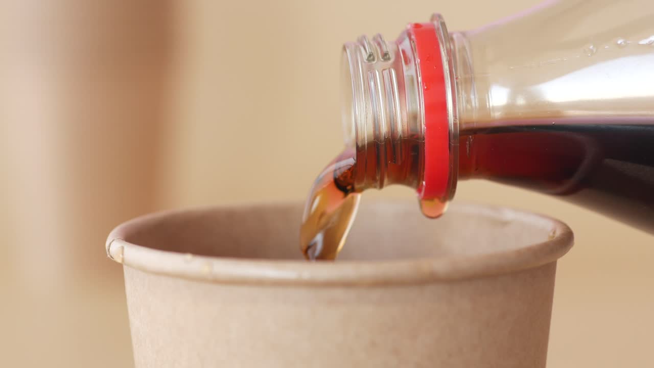 vertiendo cola en una taza de papel
