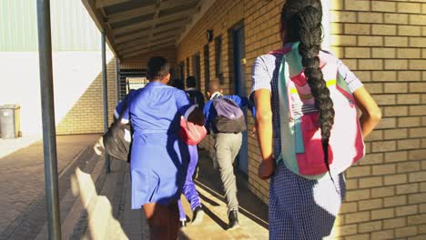 schoolchildren running in the playground at a township school 4k