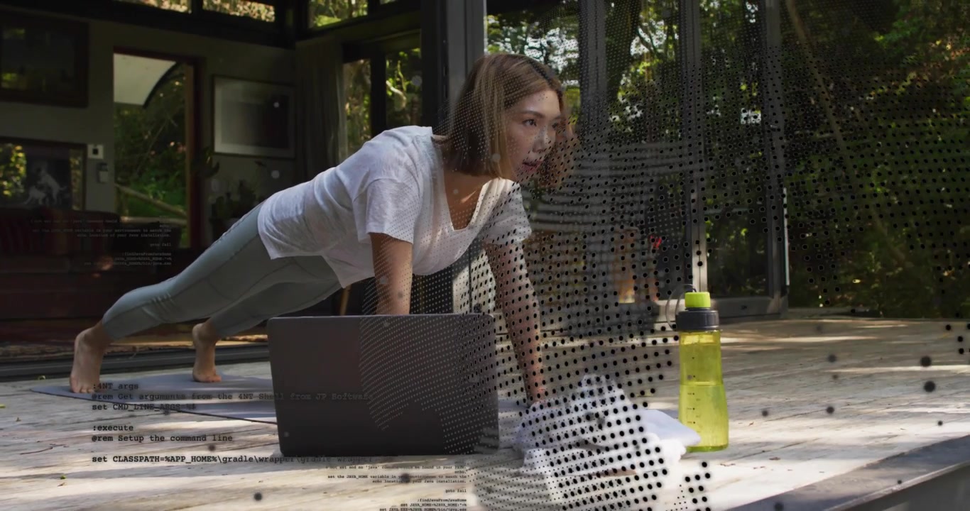 woman performing push-ups on deck with mat and laptop as fitness tutorial playing showing code dots