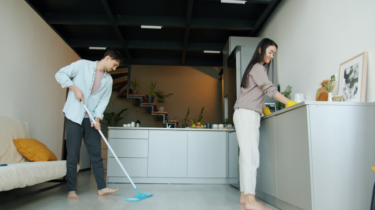 Couple Cleaning a Modern Apartment Kitchen