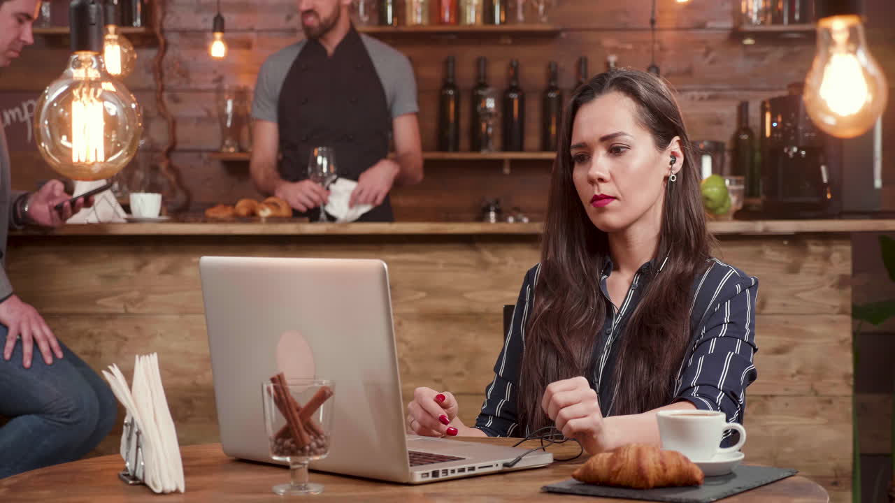 mujer trabajando en una computadora portátil en un café