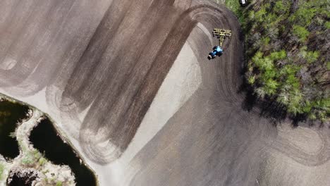 aerial top down view rotating of a tractor plow tilling a field