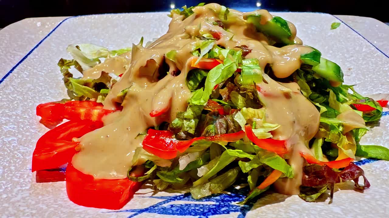 Closeup of fresh vegetable salad with tahini dressing known as Salata Tahina or Baladi Salad with Tahini