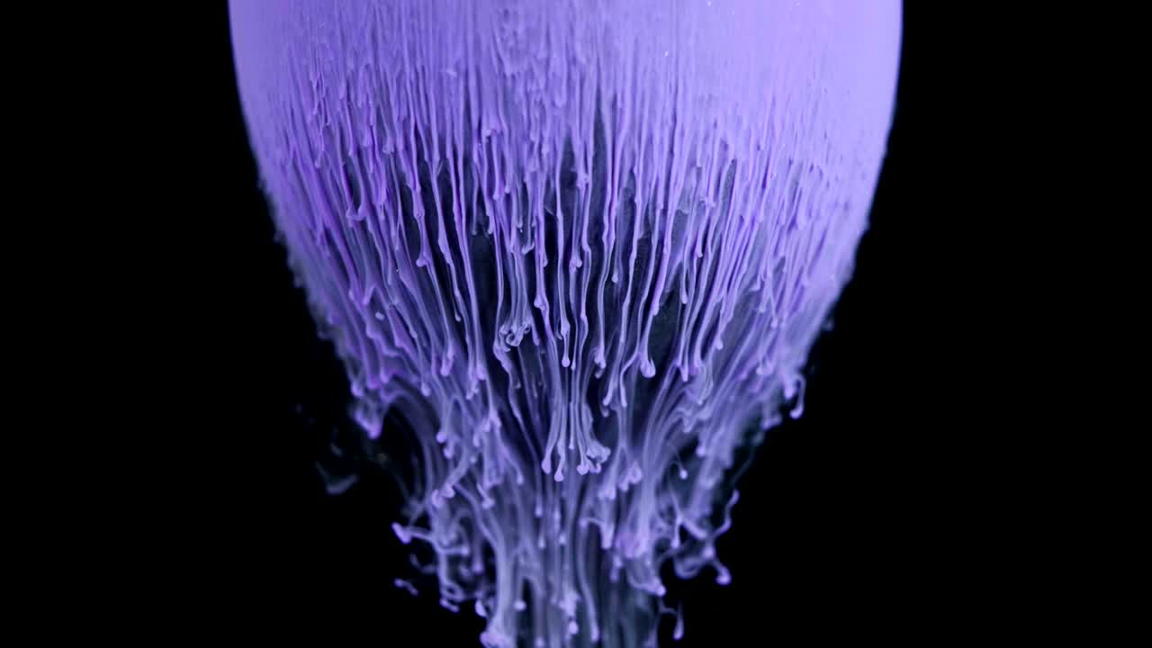 Multicolored ink paint slowly flows from the ball