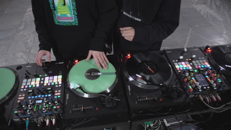 two djs performing on turntables