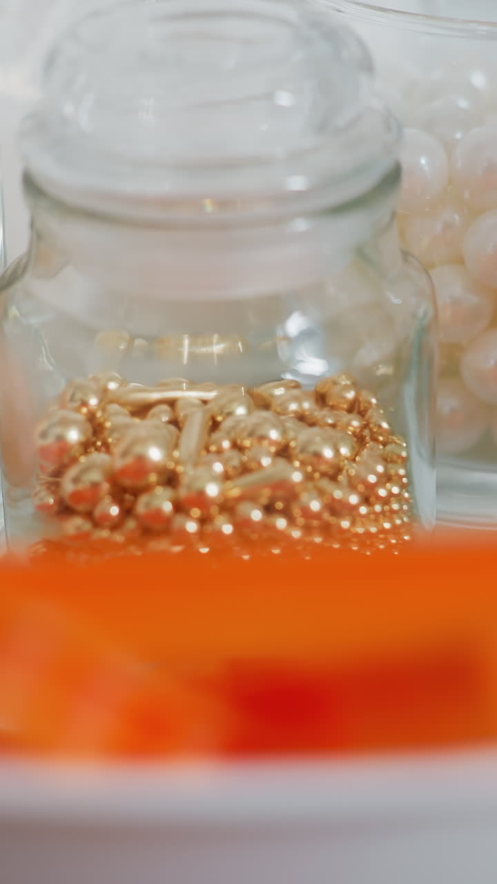 유리 항아리, 유리 컵에 설탕, 오렌지 쿠키 커터, 주방 카운터에  그에 배열 된 활기찬 식용 구슬의 클로즈업