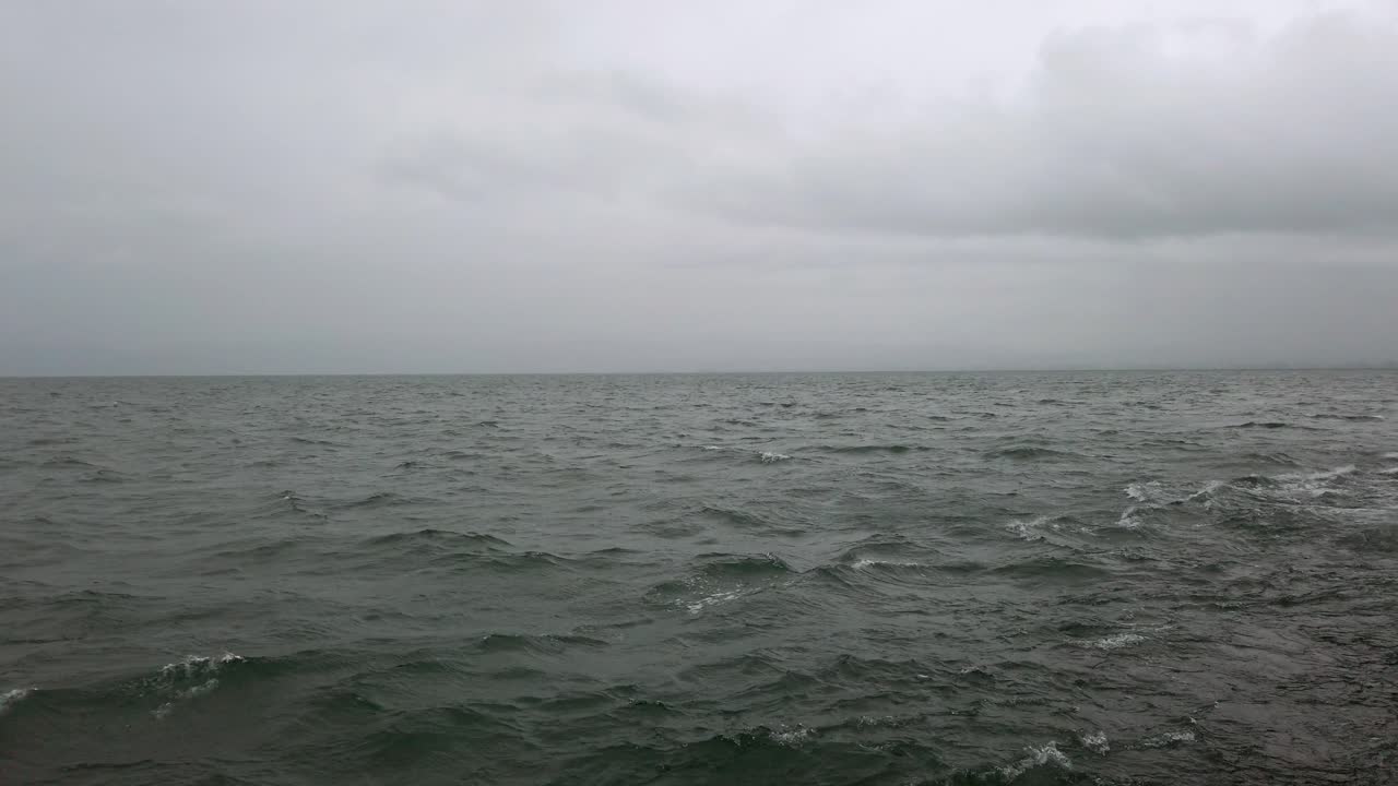 nubes oscuras y tormentosas se reflejan en las frías aguas grises del lago constance.