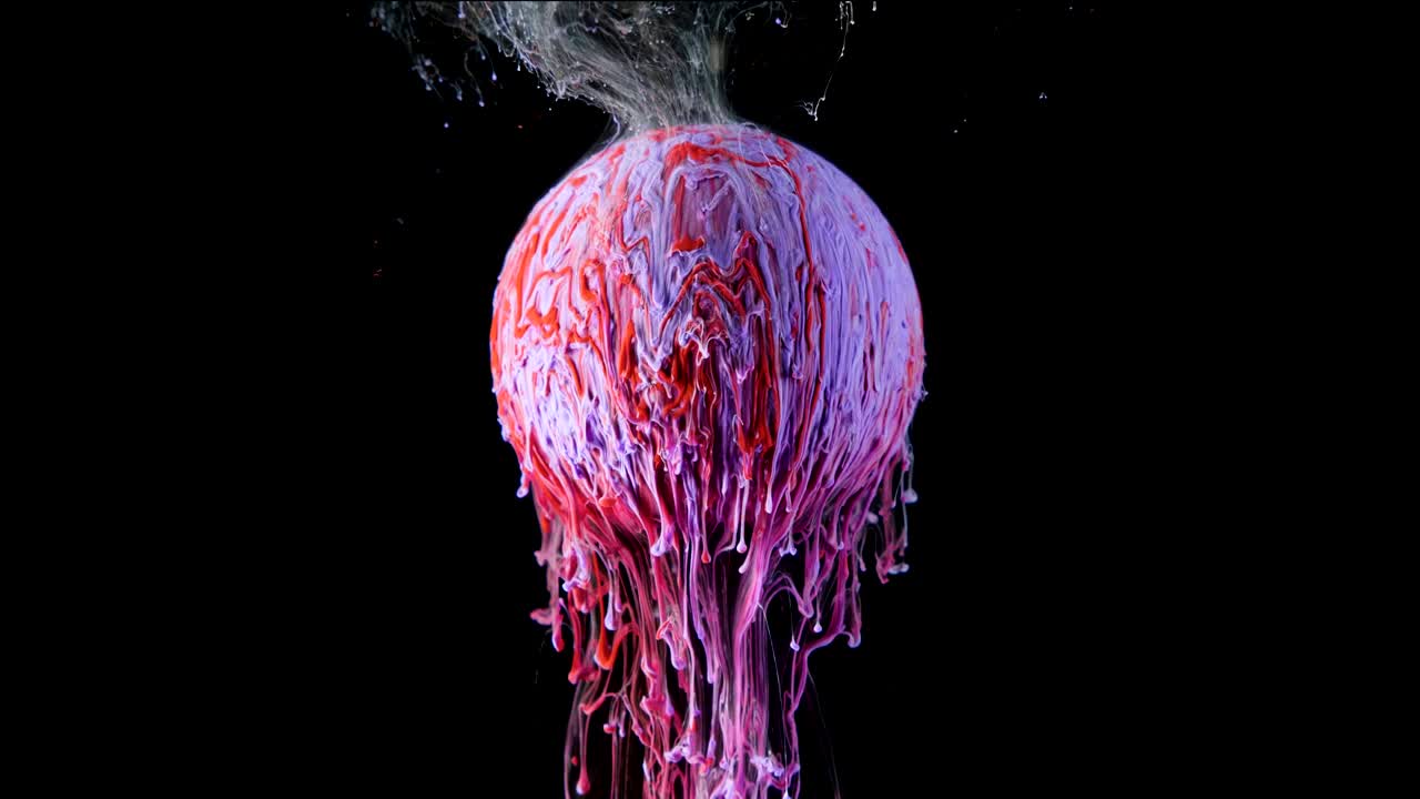 Multicolored ink paint slowly flows from the ball