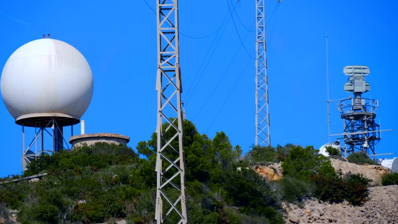 un radar meteorológico con una gran esfera blanca en la cima de una montaña