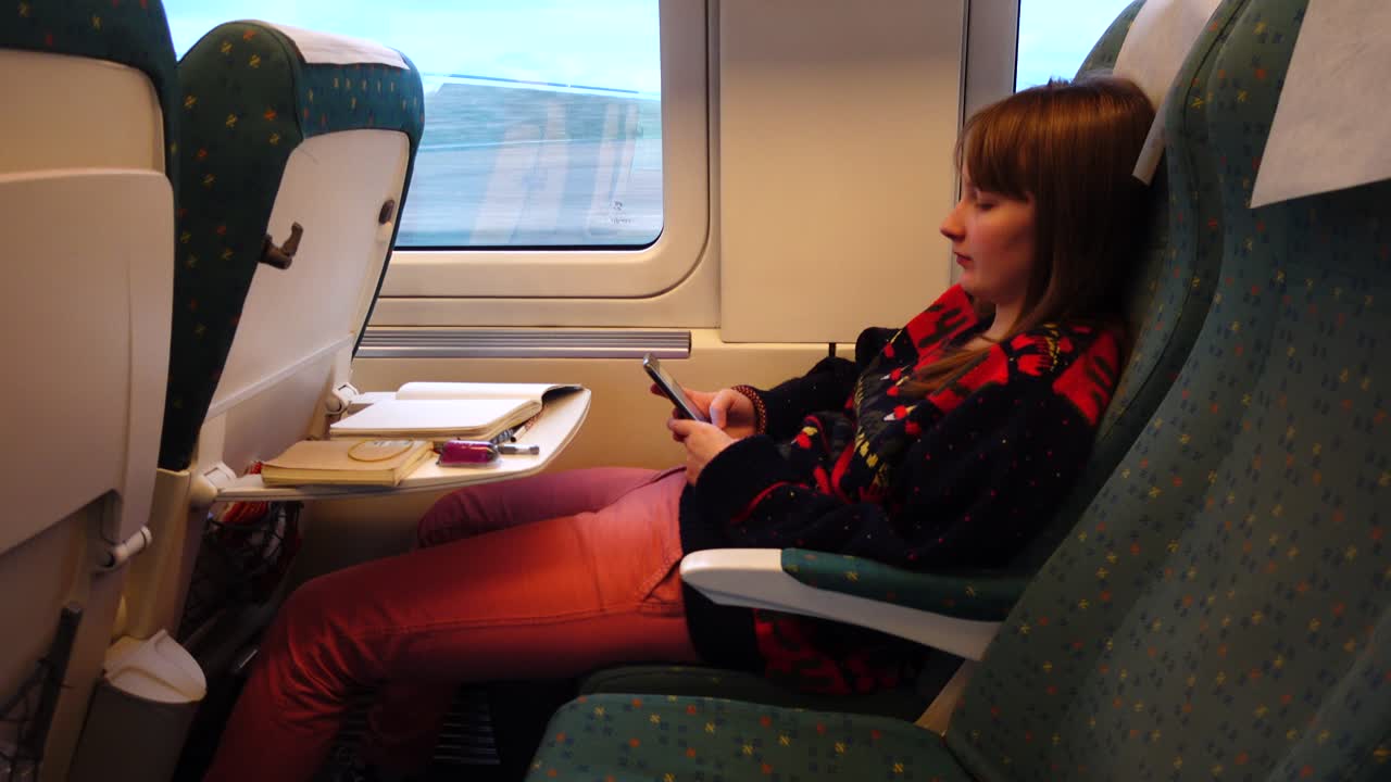 Tyttö suurnopeusjunan junavaunussa. Kuvaus liikkeessä