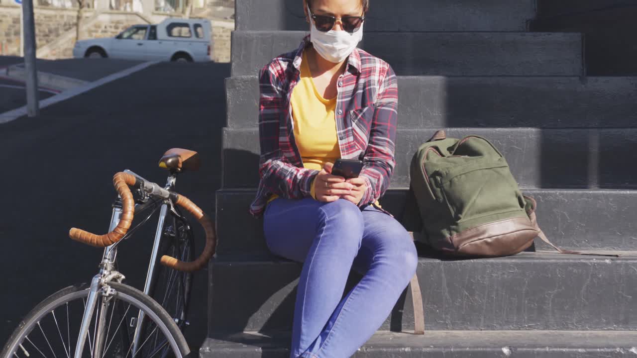 Mixed race woman wearing medical coronavirus mask on the street