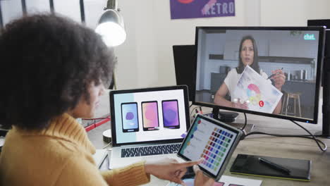 mujer de negocios afroamericana en videollamada con una colega caucásica en la pantalla