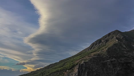 scenic clouds during summer on sunset over mountain peak