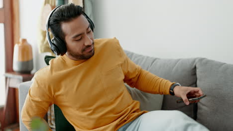 Music,-headphones-and-asian-man-relax-on-a-sofa