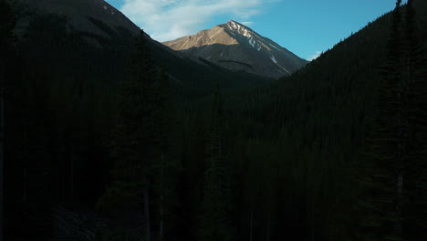 Aerial-cinematic-drone-sunrise-sunlight-early-morning-shadows-Grays-and-Torreys-14er-Peaks-Rocky-Mountains-Colorado-stunning-landscape-view-mid-summer-snow-on-top-forest-slowly-up-movement