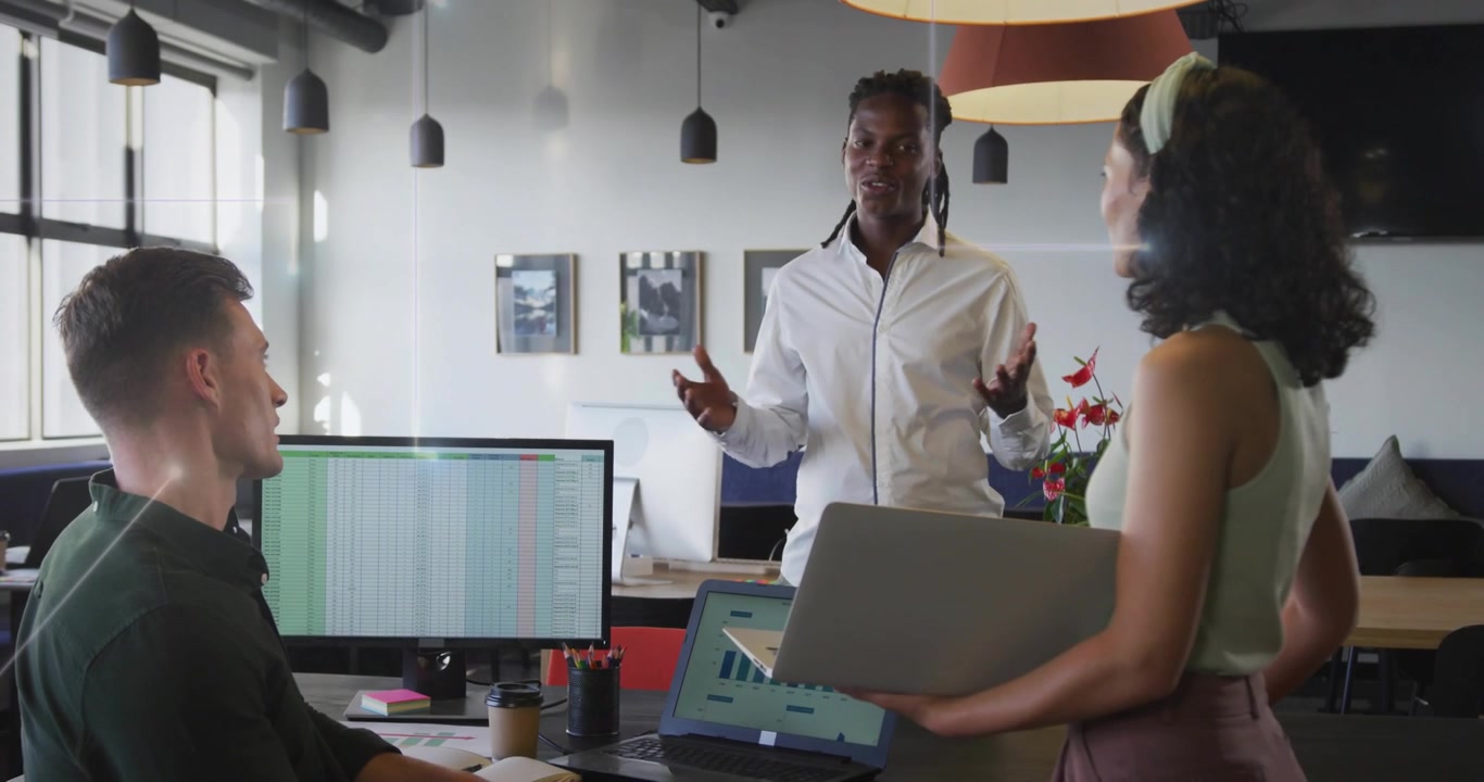 Presenter clasping hands starting business discussion with animated charts displaying on monitors