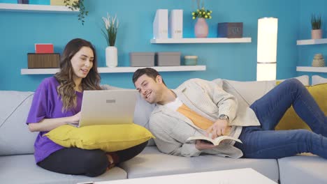 pareja feliz sentada en el sofá en casa teniendo un tiempo agradable e íntimo.
