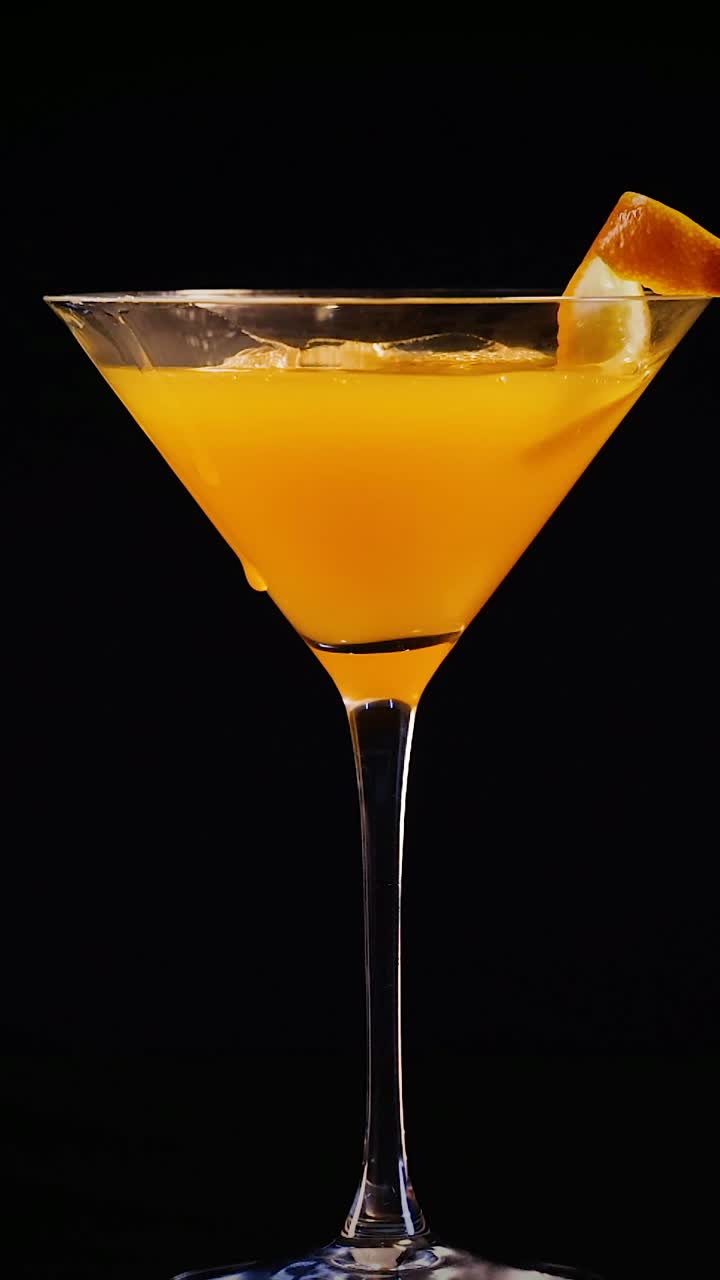 el jugo de naranja se vierte en un vaso de cóctel