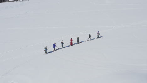 skiers in traditional tuva robes walking on fur skis in snow, aerial drone view winter
