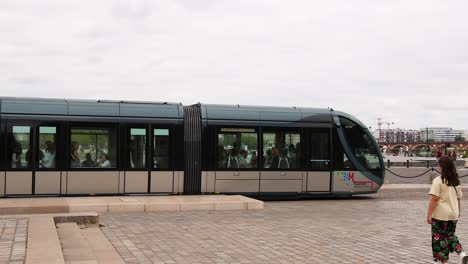 tram moving with people walking nearby