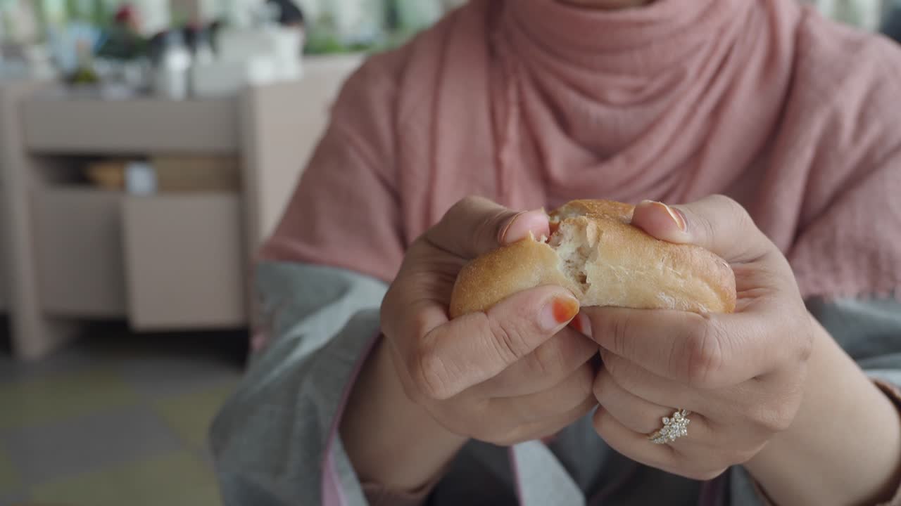 Woman eating bread in a cafe