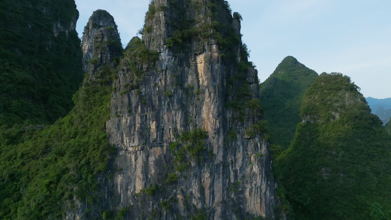 Aerial view circling a rocky, karst mountain peaks, sunset in Xingping, China